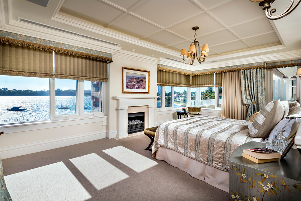 Foto de dormitorio principal clásico grande con moqueta, todas las chimeneas, paredes beige y marco de chimenea de madera