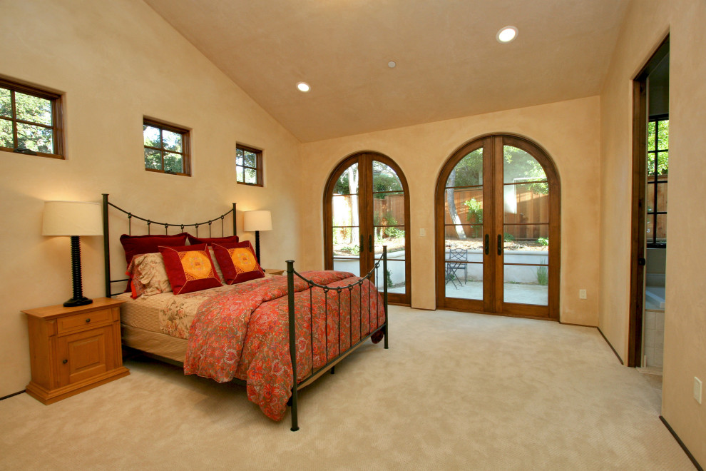 Large tuscan master carpeted and beige floor bedroom photo in Other with beige walls