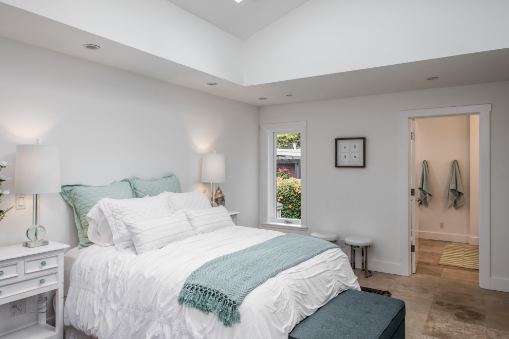 На фото: хозяйская спальня среднего размера в стиле неоклассика (современная классика) с белыми стенами, полом из известняка и коричневым полом