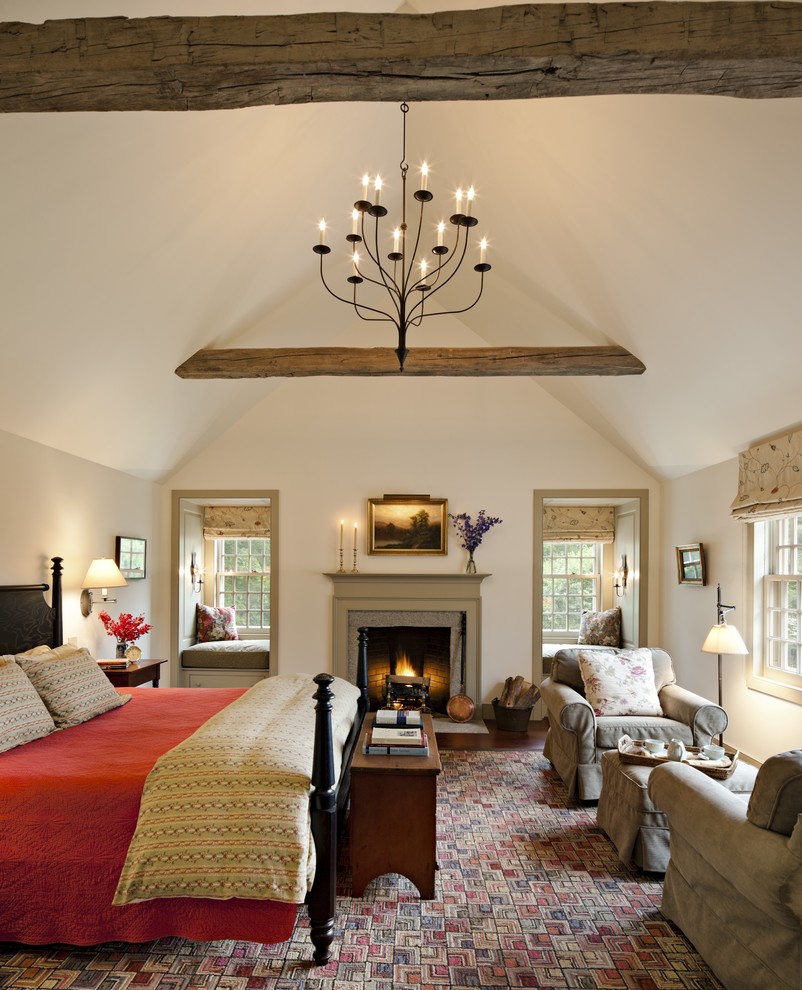 Geräumiges Landhaus Hauptschlafzimmer mit weißer Wandfarbe, braunem Holzboden, Kamin und Kaminumrandung aus Stein in New York