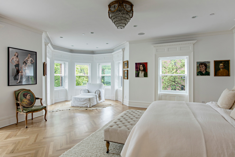 Design ideas for an expansive classic master bedroom in New York with white walls, light hardwood flooring, a standard fireplace and a stone fireplace surround.