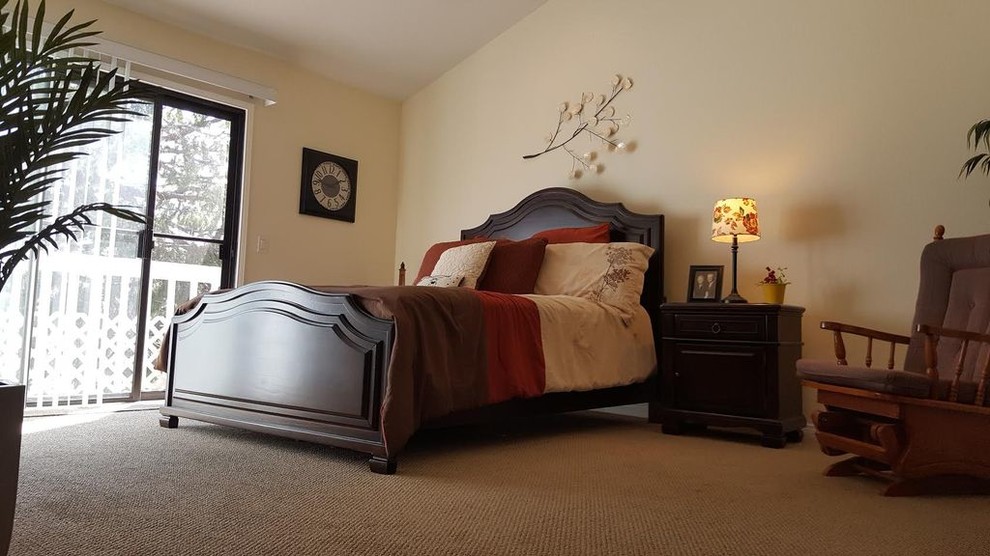 Modelo de dormitorio principal clásico grande con moqueta, suelo beige y paredes beige