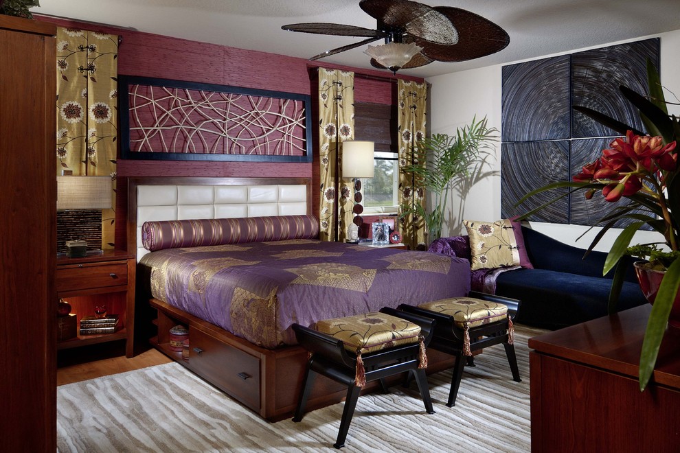 Modelo de dormitorio principal contemporáneo sin chimenea con paredes púrpuras y suelo de madera en tonos medios