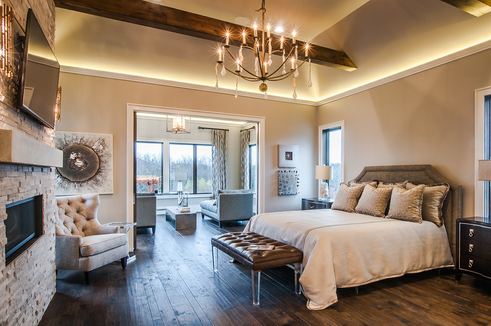 Example of a mid-sized transitional master dark wood floor bedroom design in Kansas City with beige walls, a standard fireplace and a stone fireplace