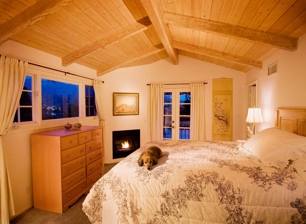 Mid-sized tuscan guest carpeted bedroom photo in Santa Barbara with white walls, a corner fireplace and a plaster fireplace