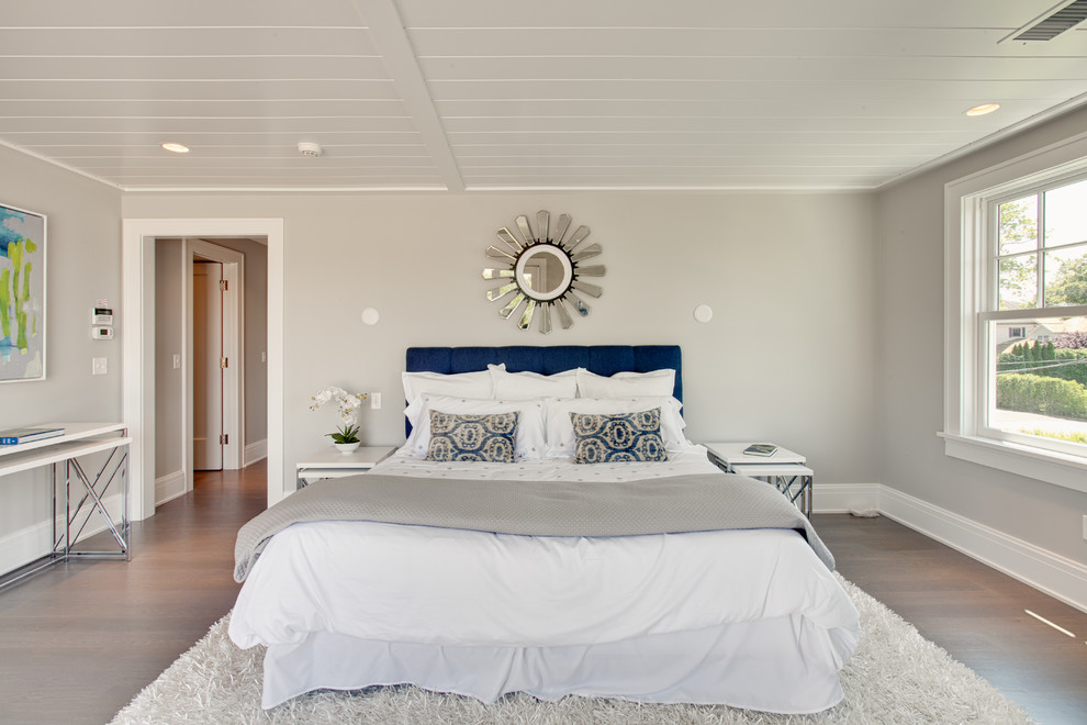 Diseño de dormitorio principal marinero grande sin chimenea con paredes grises, suelo de madera clara y suelo beige