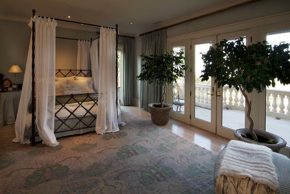 Foto de dormitorio principal mediterráneo con paredes azules y suelo de madera clara