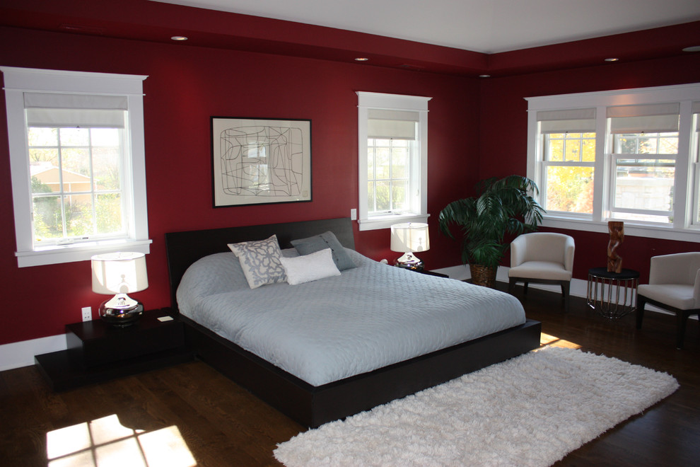 Foto de dormitorio principal tradicional con paredes rojas y suelo de madera oscura