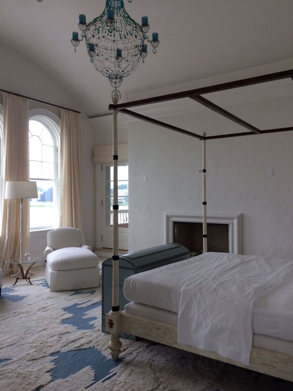 Foto de dormitorio principal nórdico grande con paredes blancas, suelo de madera clara, todas las chimeneas, suelo beige y marco de chimenea de yeso