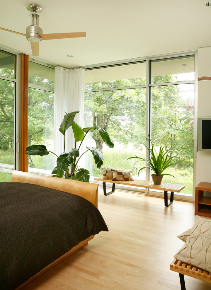 На фото: хозяйская спальня среднего размера в стиле модернизм с светлым паркетным полом, белыми стенами и коричневым полом без камина