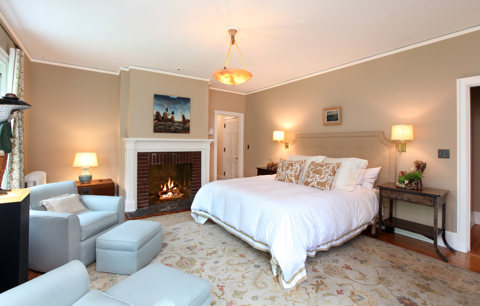 На фото: большая хозяйская спальня в классическом стиле с коричневыми стенами, паркетным полом среднего тона, стандартным камином, фасадом камина из кирпича и коричневым полом