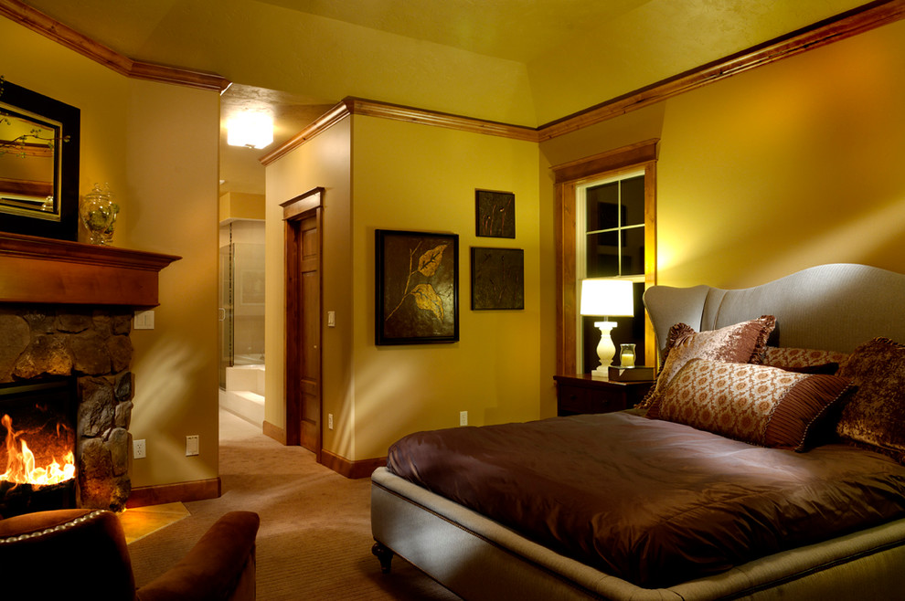 Mittelgroßes Uriges Hauptschlafzimmer mit gelber Wandfarbe, Teppichboden, Kamin und Kaminumrandung aus Stein in Seattle