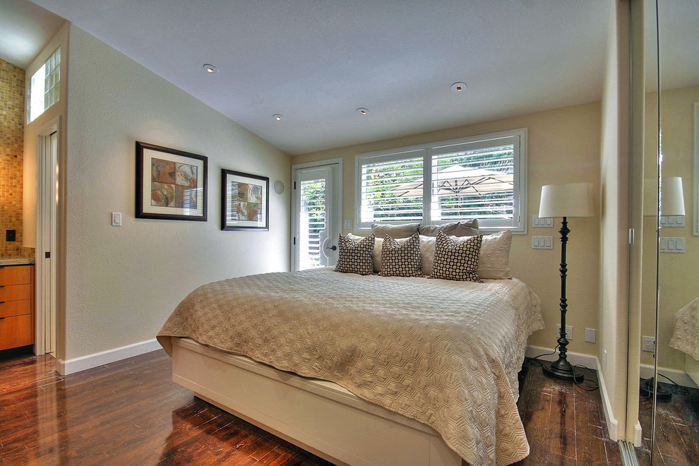 Idée de décoration pour une petite chambre parentale craftsman avec un mur beige et parquet foncé.