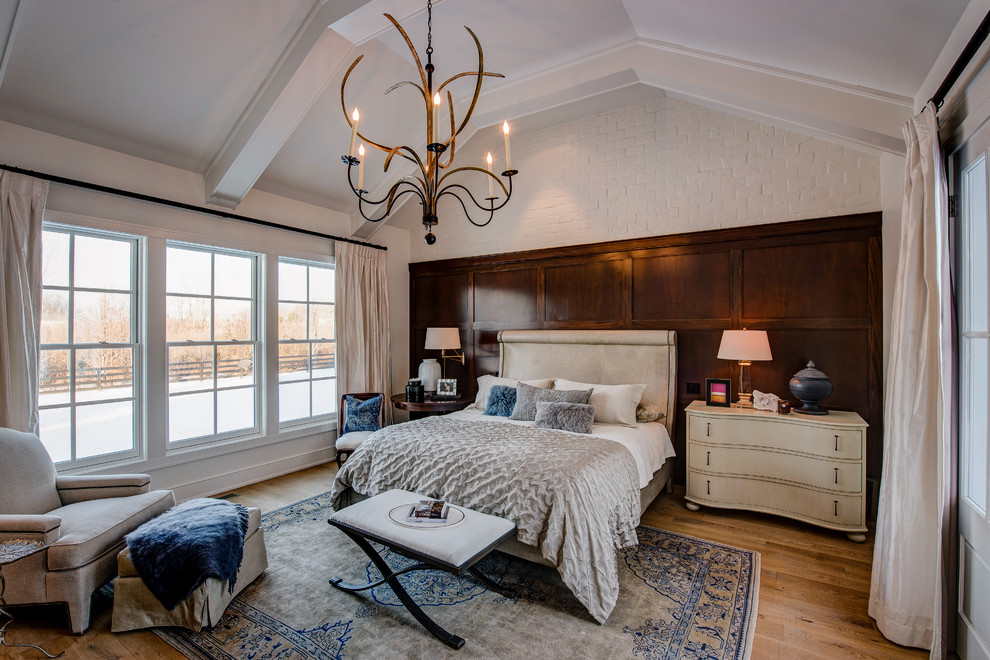 Imagen de dormitorio principal tradicional renovado grande sin chimenea con paredes blancas y suelo de madera clara