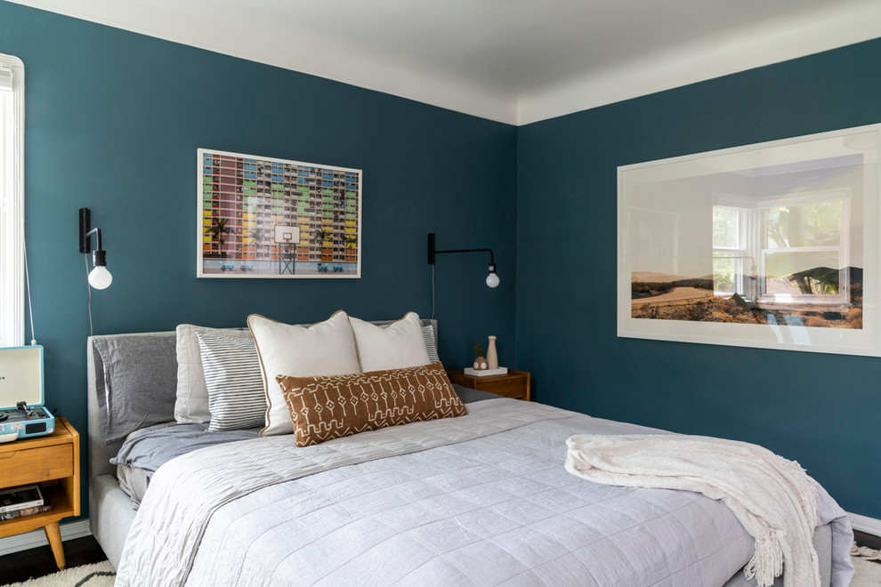 Ejemplo de dormitorio principal retro de tamaño medio sin chimenea con paredes azules y suelo de madera oscura