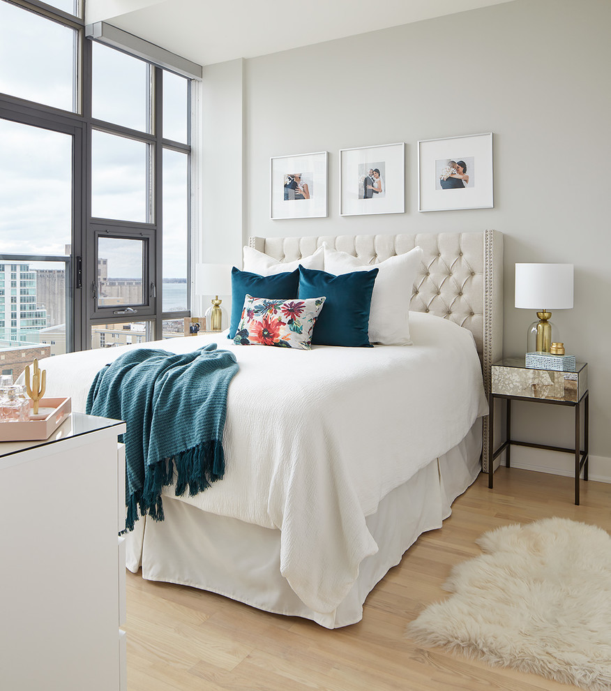 Imagen de dormitorio clásico renovado con paredes grises, suelo de madera clara y suelo beige