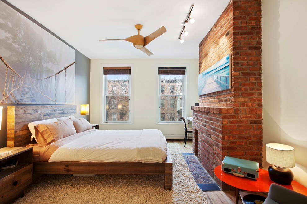 ニューヨークにある中くらいなコンテンポラリースタイルのおしゃれな主寝室 (ベージュの壁、無垢フローリング、レンガの暖炉まわり、標準型暖炉、ベージュの床) のレイアウト