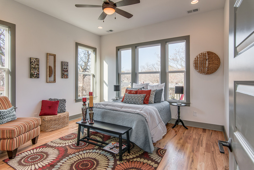 Foto de dormitorio principal de estilo americano de tamaño medio con paredes blancas y suelo de madera clara