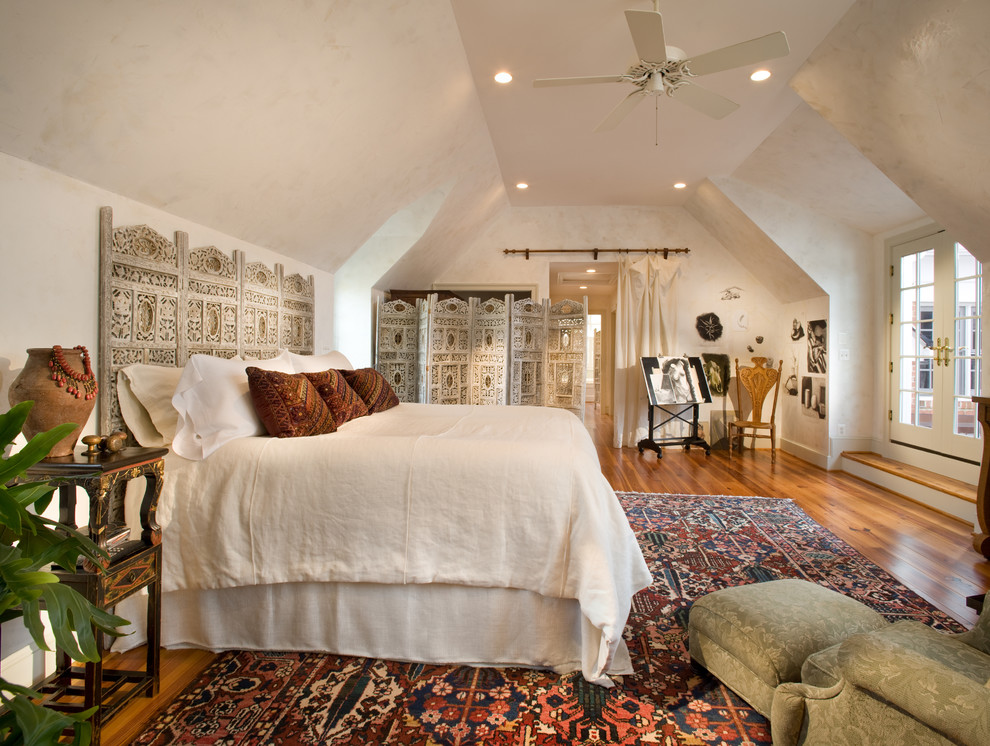 Foto di una camera matrimoniale boho chic con pareti beige e pavimento in legno massello medio