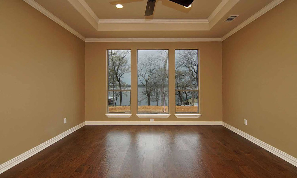 Esempio di una camera matrimoniale american style di medie dimensioni con pareti marroni, pavimento in legno massello medio e pavimento marrone