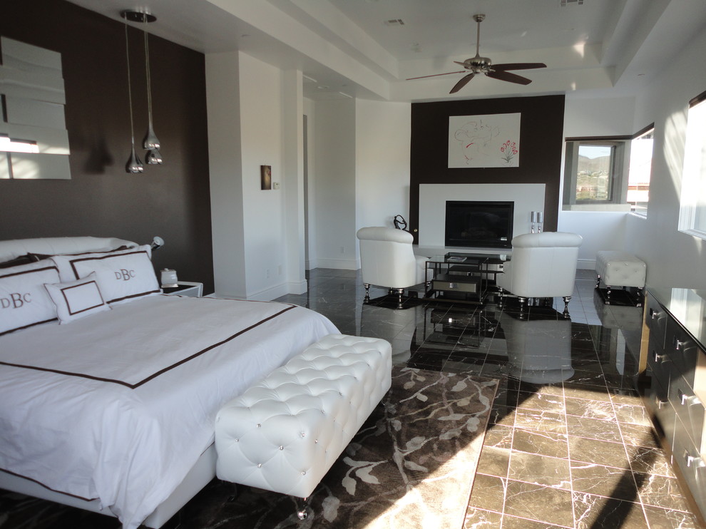 Großes Modernes Hauptschlafzimmer mit weißer Wandfarbe, Marmorboden, Kamin, Kaminumrandung aus Stein und braunem Boden in Las Vegas