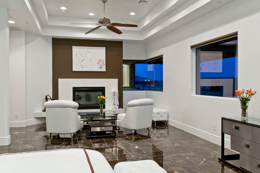 ラスベガスにある広いコンテンポラリースタイルのおしゃれな主寝室 (白い壁、大理石の床、標準型暖炉、石材の暖炉まわり、茶色い床) のインテリア