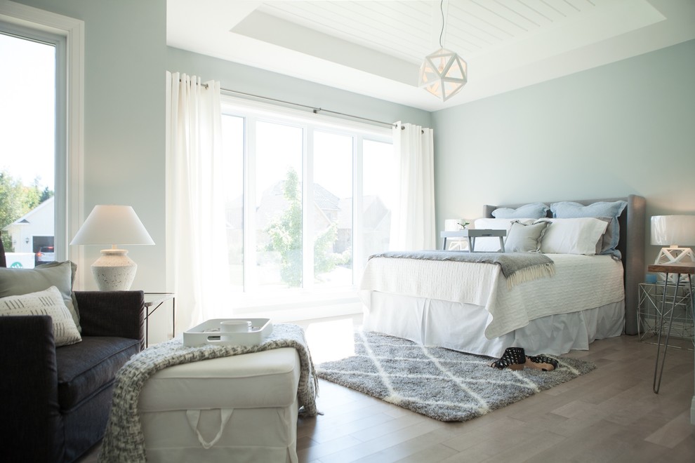 Пример оригинального дизайна: большая хозяйская спальня в стиле кантри с синими стенами, паркетным полом среднего тона и коричневым полом без камина