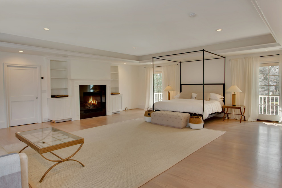 Huge transitional master light wood floor and brown floor bedroom photo in New York with white walls, a standard fireplace and a tile fireplace