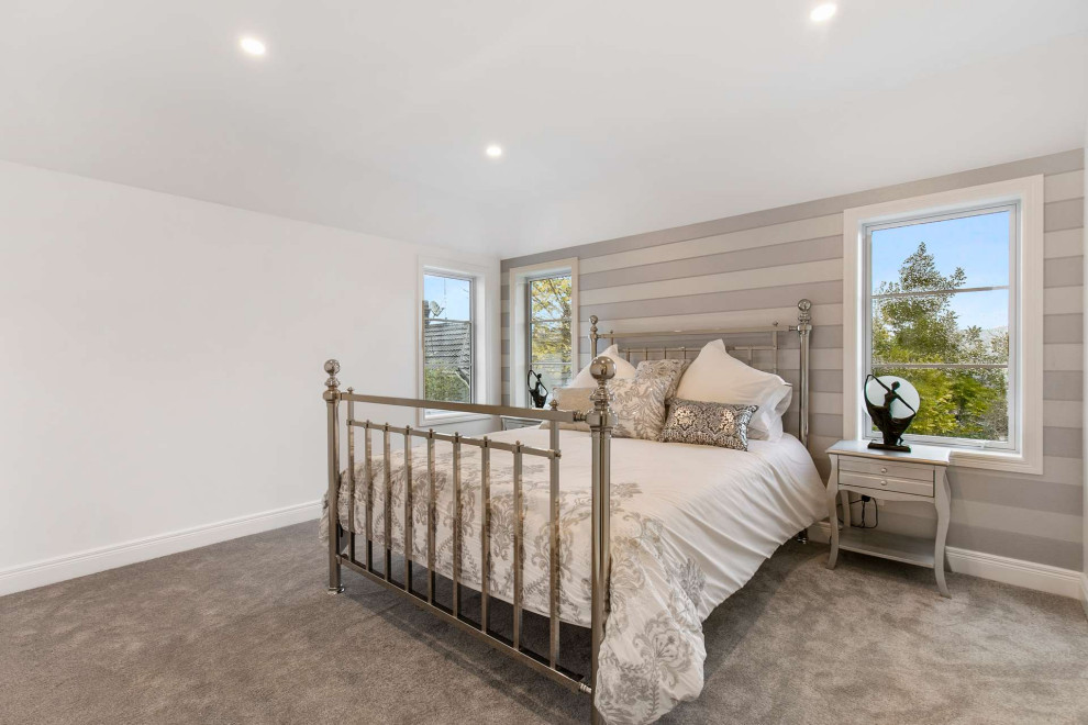 Kleines Uriges Hauptschlafzimmer mit weißer Wandfarbe, Teppichboden, beigem Boden, gewölbter Decke und Tapetenwänden in Auckland