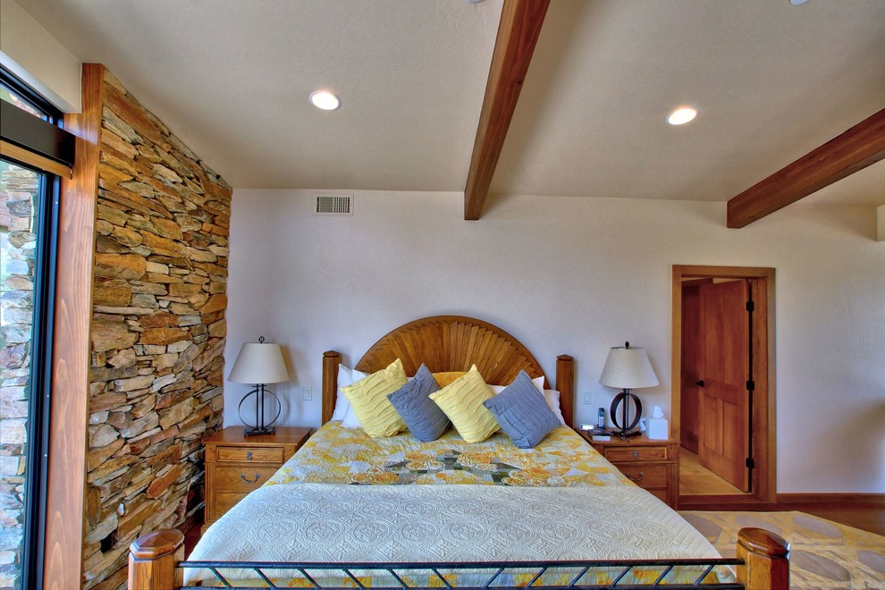 Bedroom - large southwestern master medium tone wood floor bedroom idea in Phoenix with beige walls