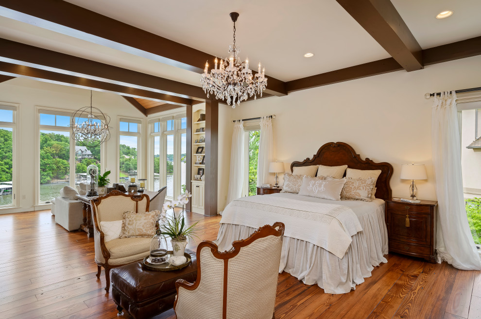 Inspiration for a large mediterranean master bedroom in Kansas City with white walls, medium hardwood flooring and brown floors.