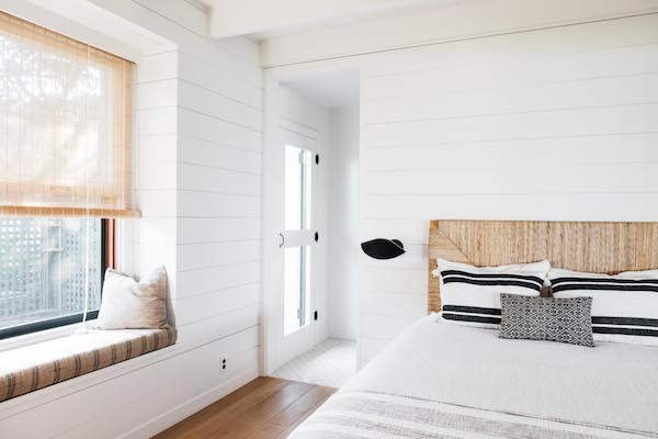 Exemple d'une chambre d'amis bord de mer de taille moyenne avec un mur blanc, un sol en bois brun, aucune cheminée et un sol marron.