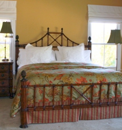 Imagen de dormitorio principal tropical de tamaño medio sin chimenea con paredes amarillas y moqueta