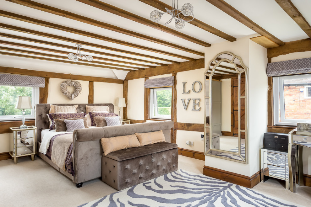 グロスタシャーにある広いカントリー風のおしゃれな主寝室 (ベージュの壁、カーペット敷き、ベージュの床、表し梁) のレイアウト