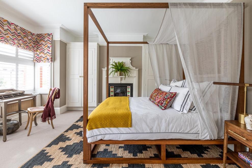 Cette photo montre une chambre chic avec un mur beige, une cheminée standard, un manteau de cheminée en carrelage et un sol beige.