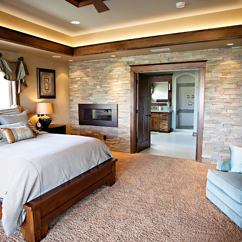 Traditional bedroom in Portland with a two-sided fireplace.