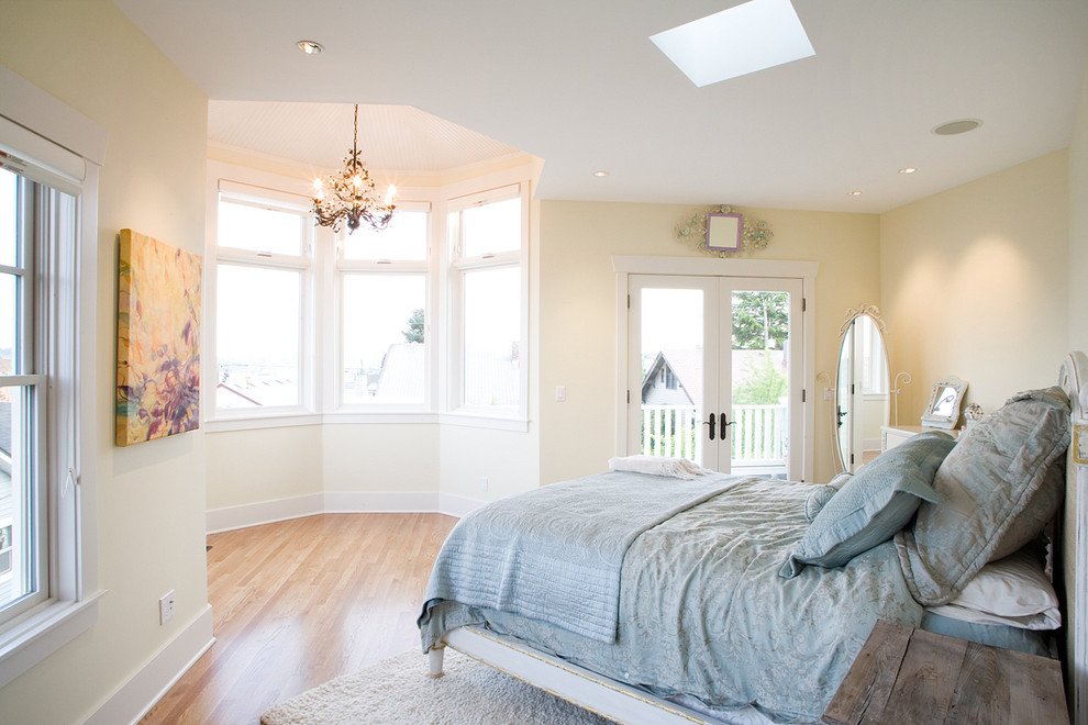 Design ideas for a traditional master bedroom in Seattle with beige walls and light hardwood flooring.
