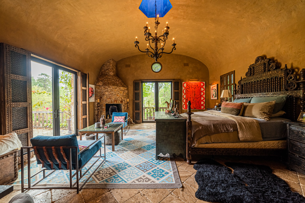 Mediterranes Hauptschlafzimmer mit brauner Wandfarbe, Eckkamin, Kaminumrandung aus Stein, braunem Boden und gewölbter Decke in Houston