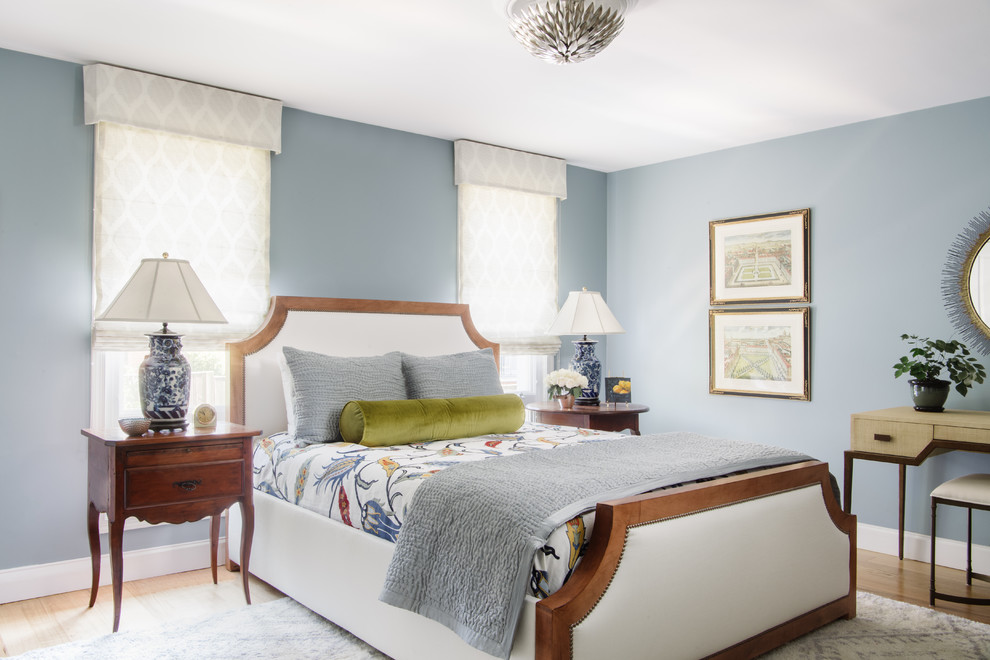 Cette photo montre une chambre parentale chic avec un mur bleu, un sol en bois brun et aucune cheminée.