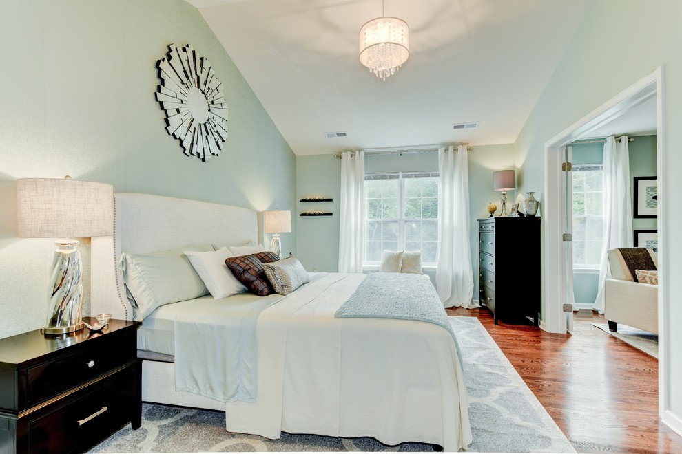 Imagen de dormitorio principal tradicional renovado grande con paredes verdes, suelo de madera en tonos medios y todas las chimeneas