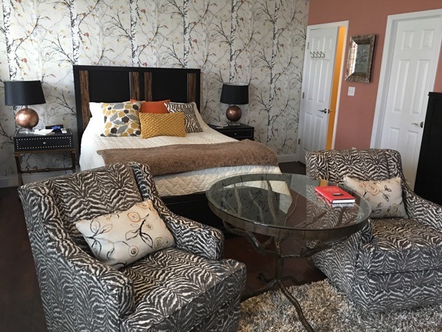 Esempio di una camera da letto chic di medie dimensioni con pareti arancioni, pavimento in vinile e camino classico
