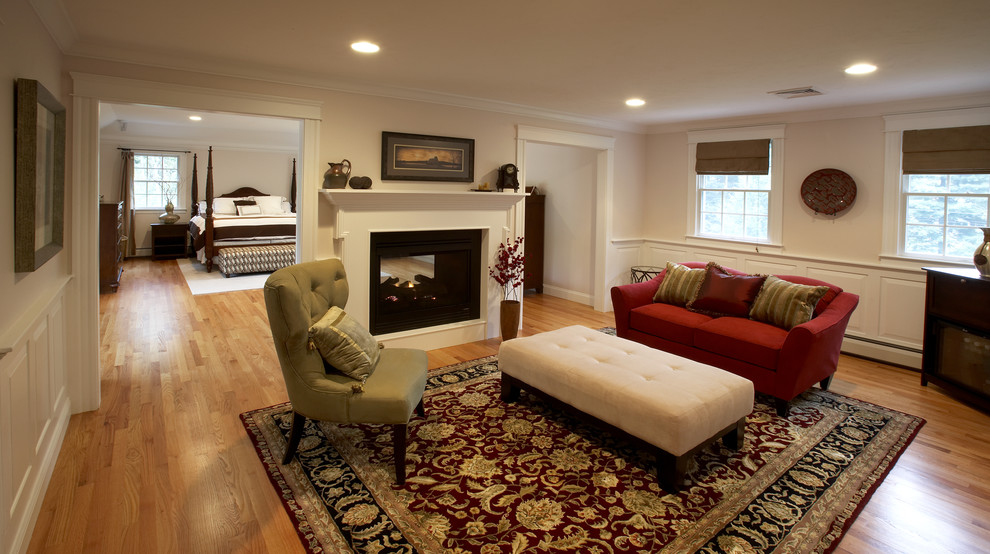 Large elegant master light wood floor bedroom photo in Boston with beige walls, a two-sided fireplace and a wood fireplace surround