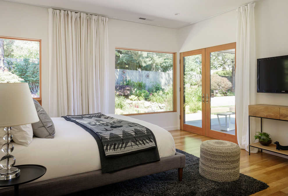 Свежая идея для дизайна: хозяйская спальня среднего размера в современном стиле с белыми стенами, светлым паркетным полом и коричневым полом - отличное фото интерьера
