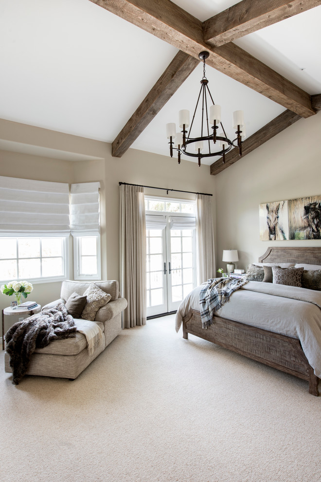 Foto de dormitorio principal rústico de tamaño medio con paredes beige, moqueta y marco de chimenea de piedra