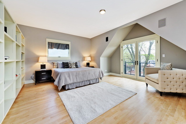 Imagen de dormitorio principal contemporáneo grande sin chimenea con paredes grises, suelo de madera clara y suelo beige