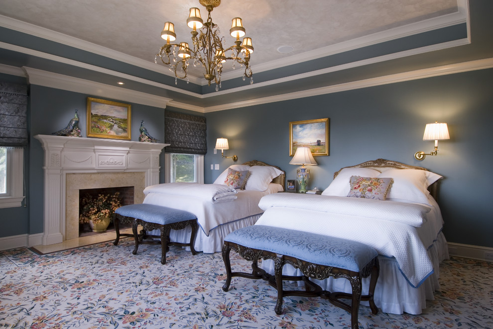 Idee per una camera matrimoniale chic con pareti blu, moquette e camino classico