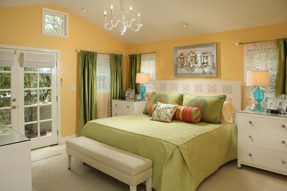 Immagine di una camera da letto design con pareti gialle