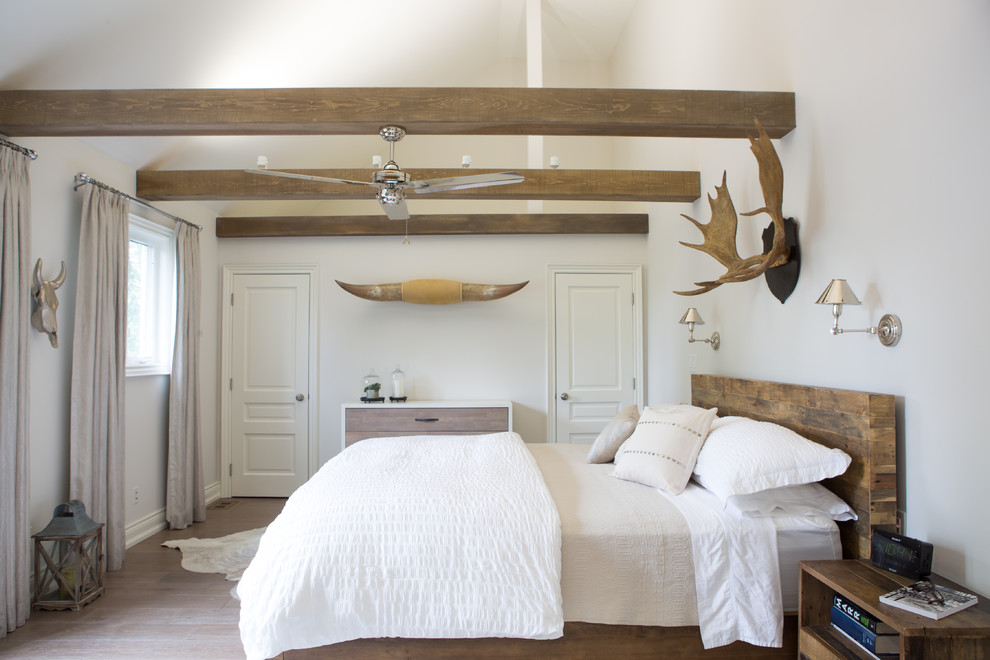 Diseño de dormitorio principal de estilo americano con paredes blancas, suelo de madera clara y suelo beige