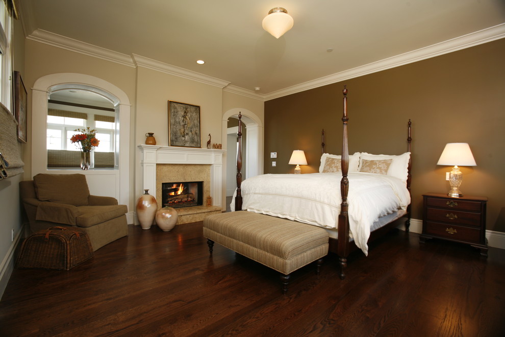 Пример оригинального дизайна: хозяйская спальня: освещение в классическом стиле с коричневыми стенами, темным паркетным полом, стандартным камином и коричневым полом