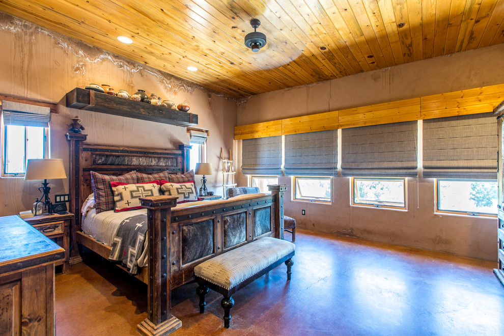 На фото: хозяйская спальня среднего размера в стиле фьюжн с оранжевыми стенами, бетонным полом и красным полом с
